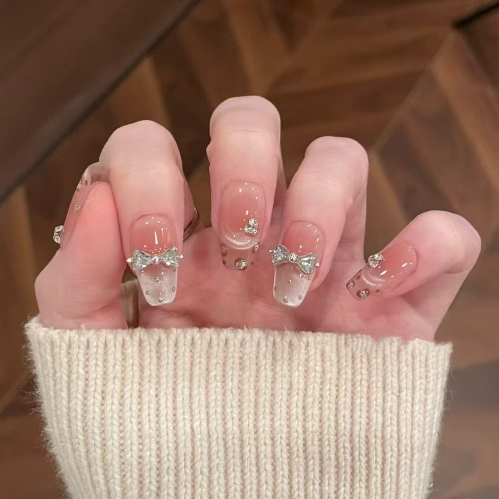 Art nails with delicate rhinestone and bow accents Bowlift