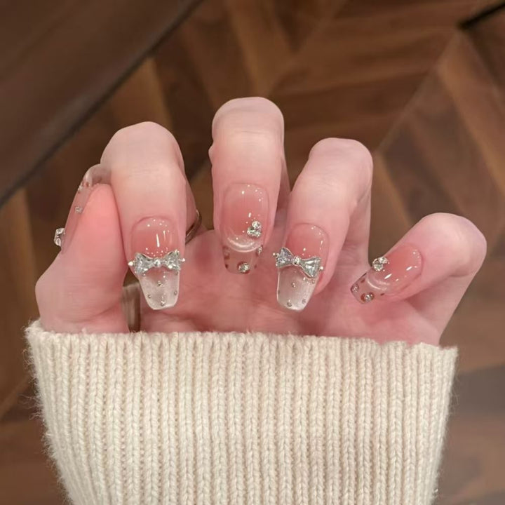 Art nails with delicate rhinestone and bow accents Bowlift