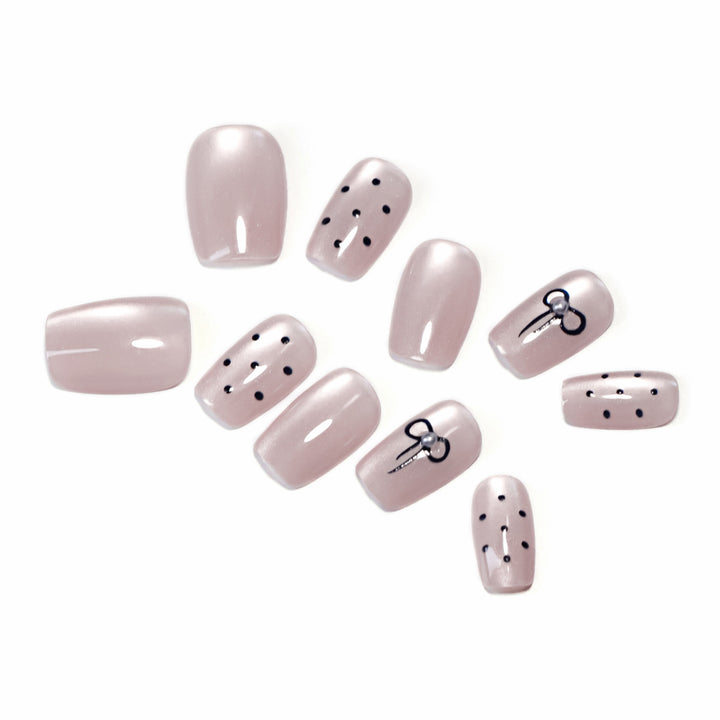 Artificial nail extensions with decorative bows and dots Bowlift