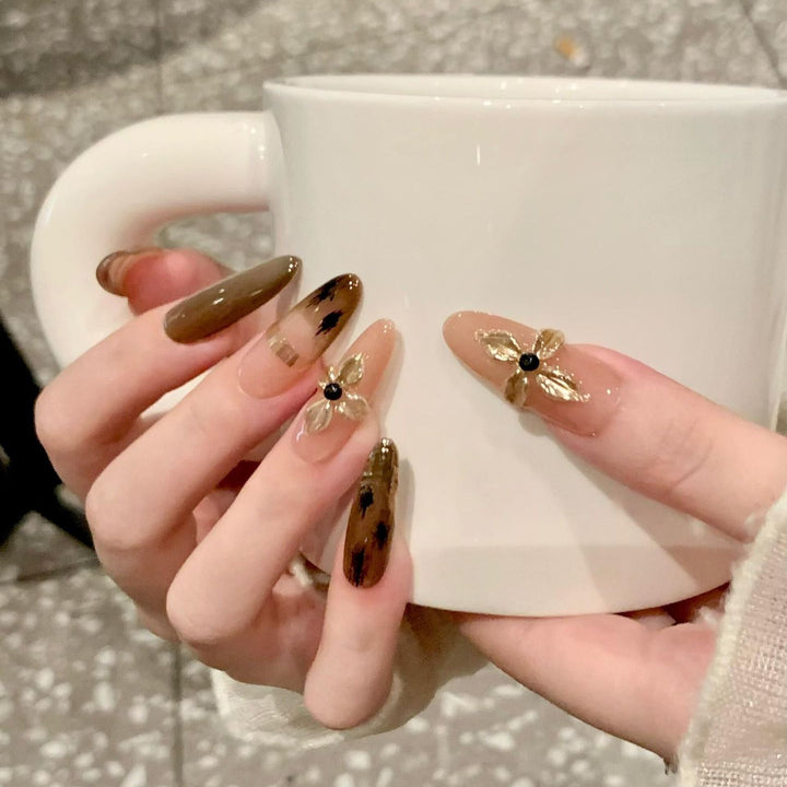 Artificial nails with elegant gold embellishments Bowlift