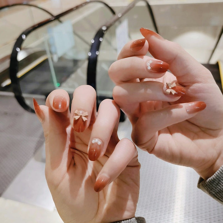 Artificial nails with elegant bow accents and pearl decorations Bowlift