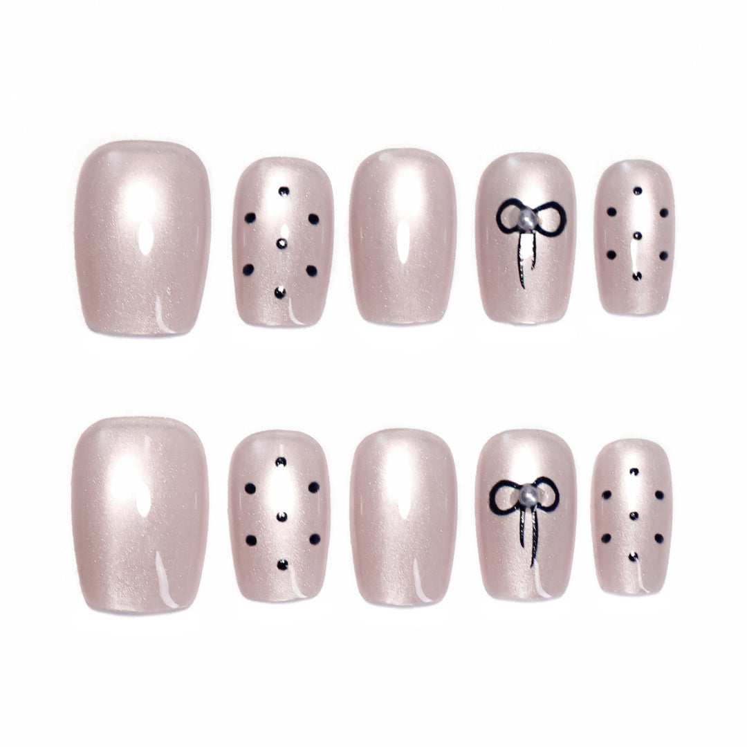 Artificial nail extensions with decorative bows and dots Bowlift