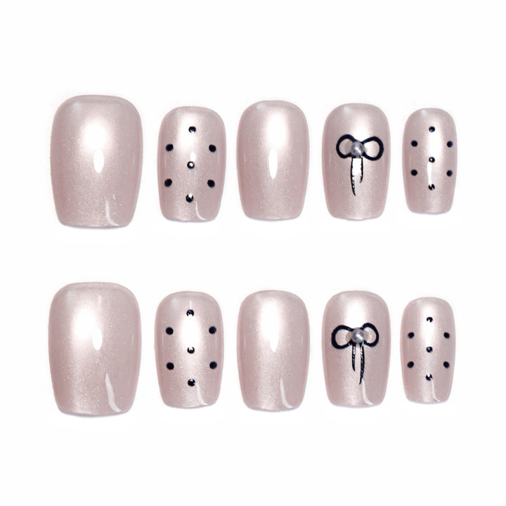 Artificial nail extensions with decorative bows and dots Bowlift