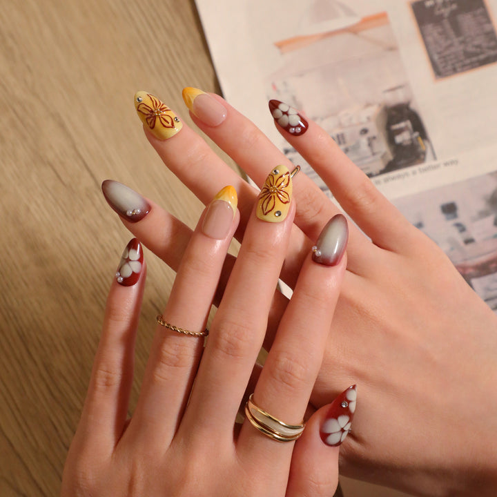 Artificial nail extensions with floral design and rhinestone embellishments Bowlift