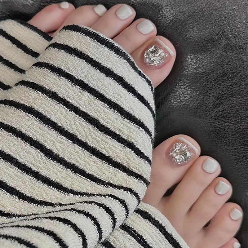 Artistic toenail art with rhinestone and glitter elements Bowlift