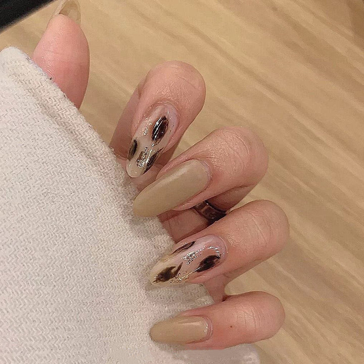 Artificial nail extensions with modern design and glitter accents Bowlift