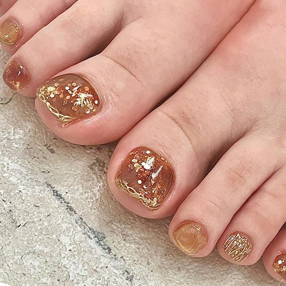 Artistic toenail design with glitter and golden accents Bowlift