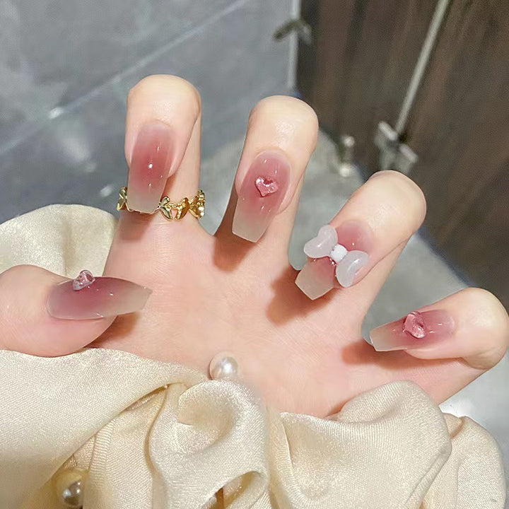 Artful acrylic nails with heart and bow design Bowlift