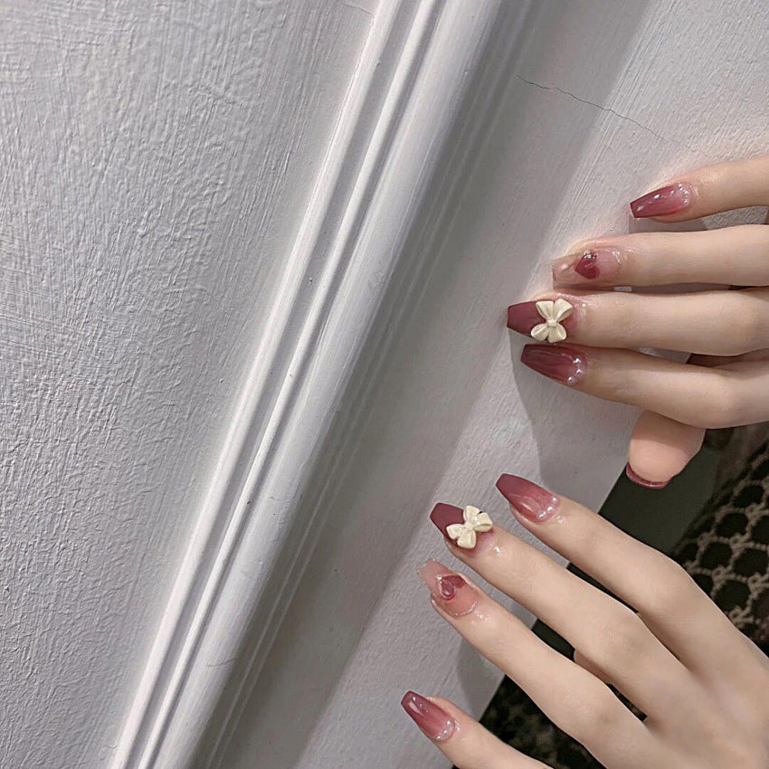Glamorous artificial nails with heart design and glittering accents Bowlift