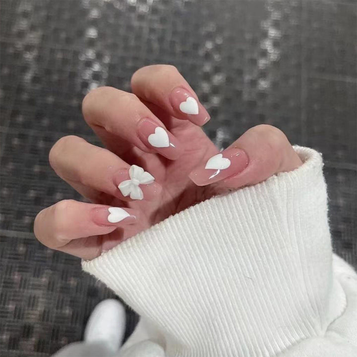 Artistic acrylic nails with heart and bow motifs Bowlift