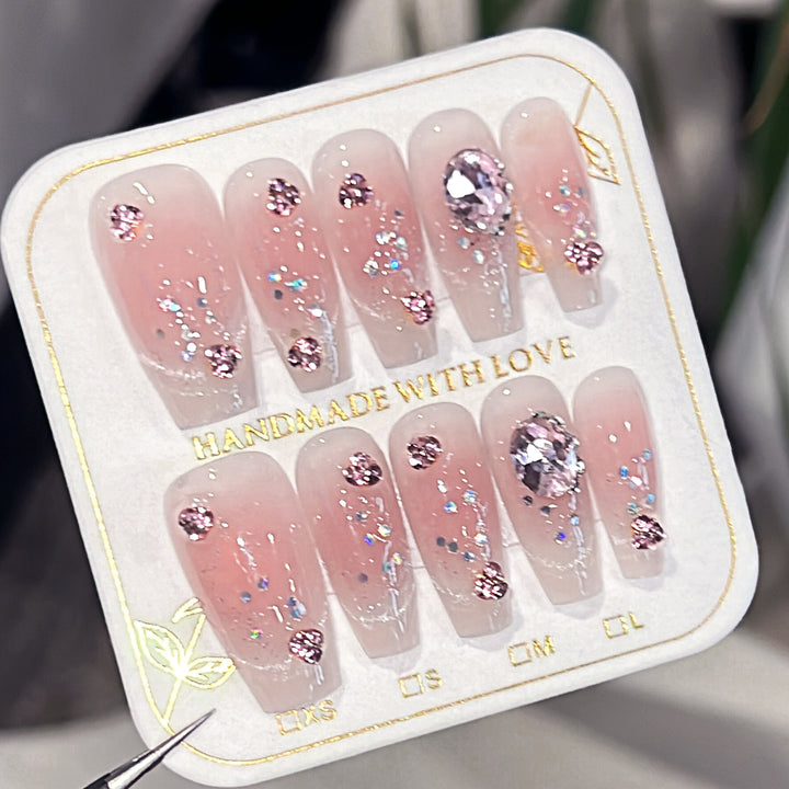 Artificial nail extensions with artistic glitter accents Bowlift