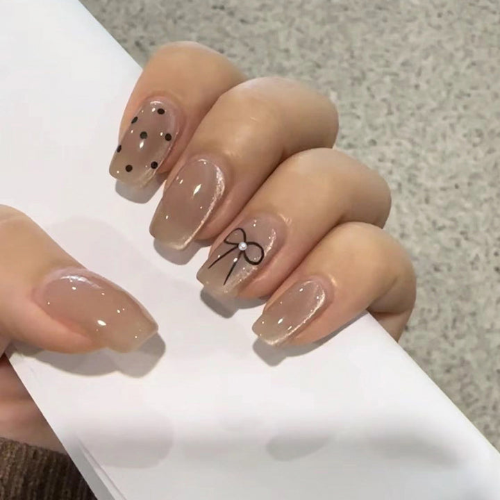 Artificial nail extensions with decorative bows and dots Bowlift